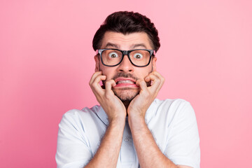 Closeup photo of young funnny handsome attractive bearded man bite fingers nails nervous face wear glasses deadline work manager isolated on pink color background - obrazy, fototapety, plakaty