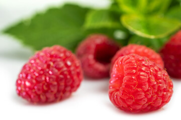 Isolated berries. Pile of raspberry fruits with leaves isolated on white background