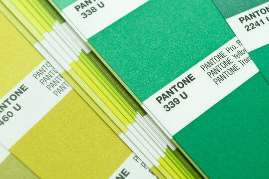 Berdsk, Russia - 28 May 2022: Pantone color guide. Palette of yellow and green color shades. A sample of the chromaticity of the colors system. Reference colors of paints. Selective focus