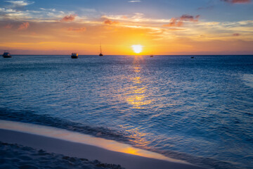 Fototapeta na wymiar Aruba idyllic caribbean beach with boats at sunset, Dutch Antilles Sea