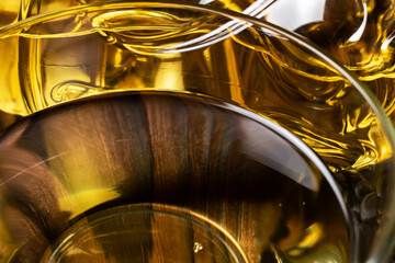 Sunflower oil in glass transparent bowl on a wooden background. Close up