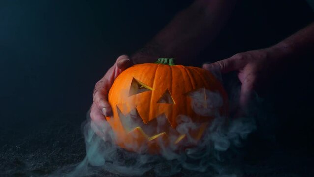 Halloween background with a glowing pumpkin and heavy smoke