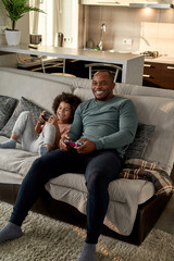 son with open mouth and father playing video game © Svitlana