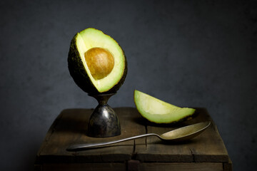 Ripe Avocado cut open with a spoon still life fine art. - 534551074