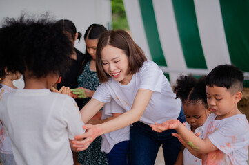 teacher and children playing color in Art join hand in hand fun together