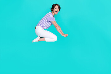 Fototapeta na wymiar Full length photo of impressed funky girl dressed purple t-shirt flying empty space isolated teal color background