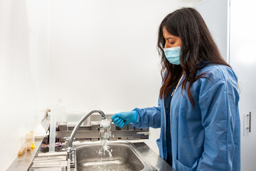 Young female scientist dewaxing paraffin embedded tissue samples in the laboratory. Xylene-based...