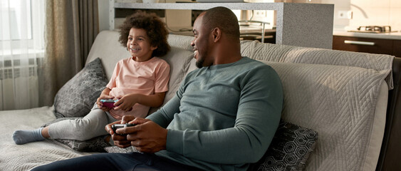 Father look at son during they play video game