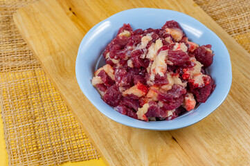 Heap of raw chopped beef, Fresh beef slice in a bowl on a wooden chopping bord.