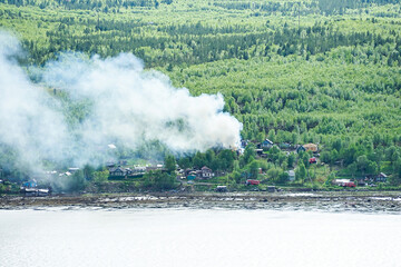 Fire in the village on the shore of the Kola Bay.