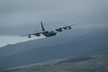 Fototapeta na wymiar C-130 Hercules transport aircraft low level flying training in mach loop valley Wales