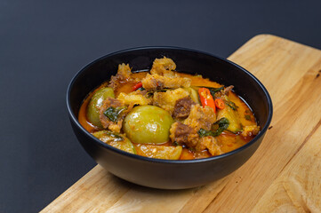 Top view of Curry with Beef Recipe in a black bowl (Panang Neua), Thai food Beef peanut-coconut cream curry, Thai curry red soup,Thailand tradition red curry with beef.