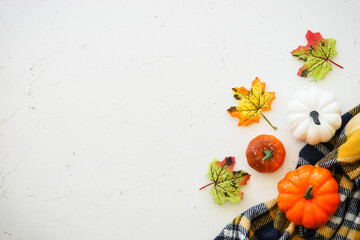 Fototapeta na wymiar Autumn flat lay background with copy space at white marble table. Pumpkins, leaves and fall decorations.