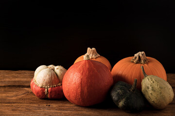 Various orange and green pumpkins on rustic wooden table. Concept autumn, halloween, harvest. 