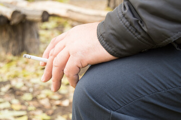 Cigarette in the hand of the old men, the concept of Smoking cessation, the fight against nicotine addiction