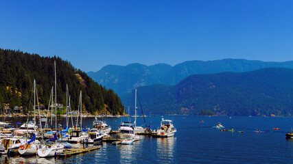 Fototapeta na wymiar Watercraft, paddleboarders and kayakers off Deep Cove, BC, on a hazy summer day.