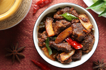 Spicy red beef fry curry and brown rice South Indian dish Kerala, India. side of Ghee rice, Appam, Parotta, Puttu. traditional Christian Muslim feast dish. Buffalo roast, meat pepper fry with coconut.