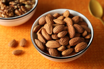 Almonds or badam dry fruits and nuts in white background layout Kerala India. Protein fiber rich food snack diet mixed nuts layout seeds, food for muscle body building.