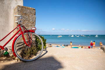 Vieux vélo rouge en bord de mer sur l'île de Noirmoutier en France.