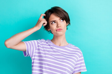 Photo of gorgeous pretty funky positive girl dressed striped t-shirt look empty space arm on head isolated on teal color background