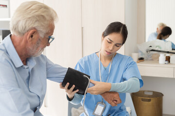 Female nurse measure the pressure senior man at hospital ward. Asian female nurse caring elderly man patient in room at nursing home. Hospital care and older adults concept