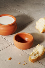 bread, milk in a clay jug and empty pottery