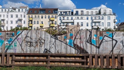 Häuserfront hinter Bretterzaun mit Graffiti