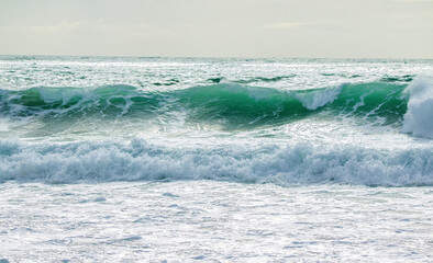 Naklejka na ściany i meble Amazing silver waves rolling towards the shore in portugal