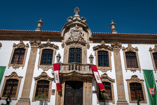 Casa brasonada com um belo brasão esculpido em granito na fachada principal numa vila de Portugal e com algumas bandeiras sobre a varanda e a fachada com as cores e o brasão da bandeira de Portugal
