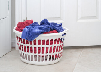 Laundry basket full of towels on floor
