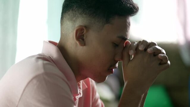 A spiritual hispanic man praying to God for better times. Faithful South American person in meditation hoping