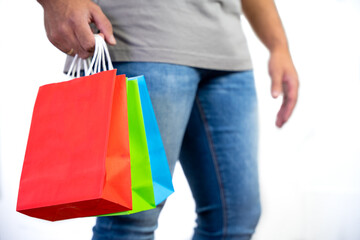 close-up of unrecognizable young man holding some colorful bags - concept shopping, black friday, sales, christmas