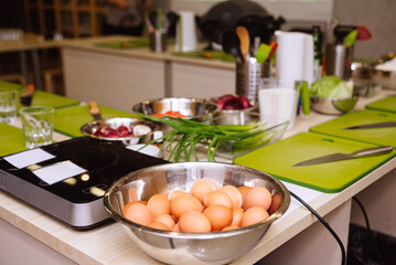 Cooking tables (working stations) prepared before the cooking master class. Cutting boards, raw food, kitchen utensils.