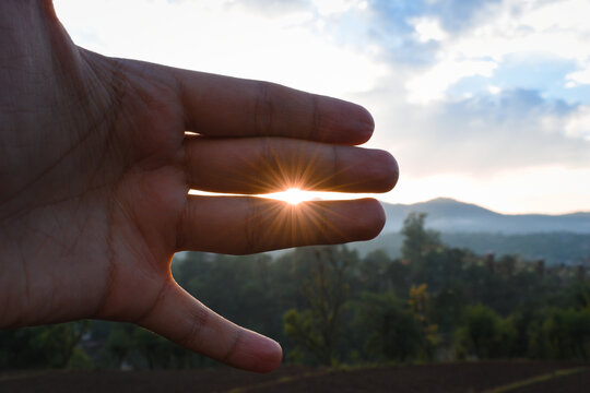 Sun rays coming in between two fingers void, evening time photograph