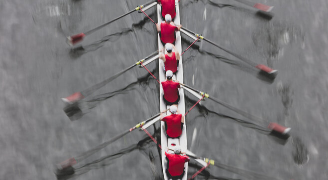 Overhead view of a crew rowing in an octuple racing shell boat, rowers, motion blur.