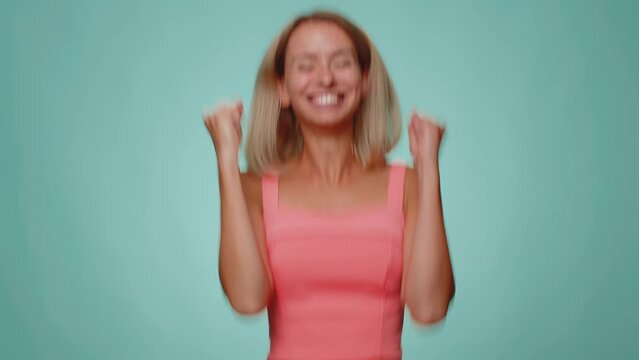 Countdown to holiday birthday celebration. Cheerful young woman 20s counting in reverse order from five to one on blue studio background. Win scream, winner gesture. Happy New Year Merry Christmas