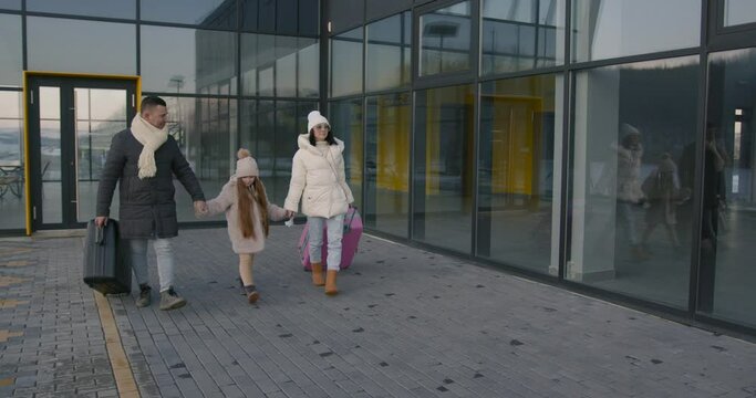 Young family dressed in winter clothes at the airport