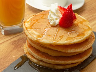 stack of pancakes with syrup and cherry