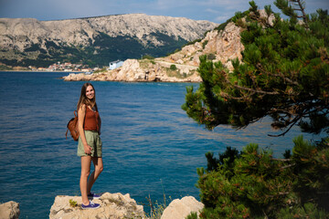 girl stands on the shore of a rocky bay in croatia at sunset, sunset over the adriatic, krk island