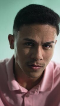 One serious hispanic latin man portrait face closeup looking at camera in vertical video
