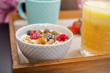 Cute and healthy breakfast with coffee, orange juice and a bowl of yogurt and fruit in a brunch style