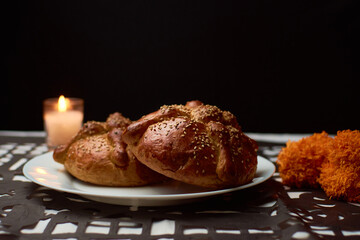 Bread of the dead with cempasuchil flowers, candles around and placed with confetti with dia de muertos shapes