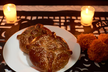 Bread of the dead with cempasuchil flowers, candles around and placed with confetti with dia de muertos shapes