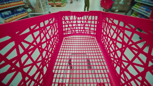 View of the empty shopping red trolley cart without food. Timelapse of shopping at the supermarket. Inflation. Consumer basket. Crisis. Decrease in purchasing power