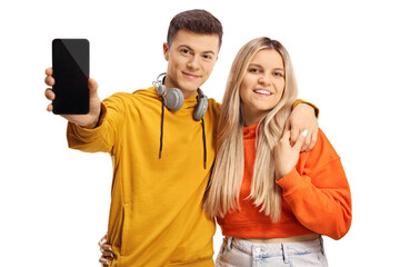Young man and woman in embarace showing a smartphone and smiling