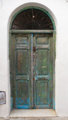 Puerta de madera maciza pintada de verde y arco en la parte superior. Solid wood door painted green and arch at the top.