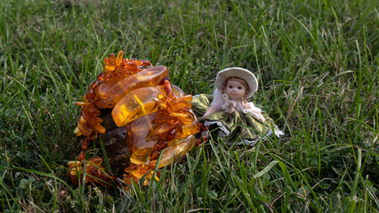 Orange Baltic amber bracelet on the green grass.  Handmade Baltic amber jewelry and an old little...