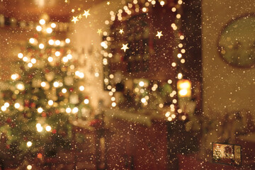 Weihnachtliche Innenraumszene in abstrakter Unschärfe - von außen durch heftigen Schneefall betrachtet