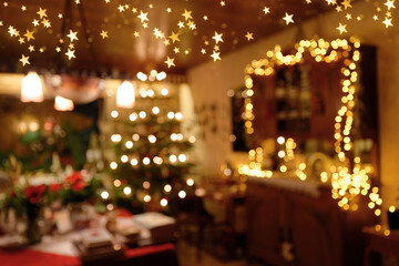 Fototapeta premium Weihnachtliche Wohnraumszene mit Deckensternlichtern in abstrakter Unschärfe
