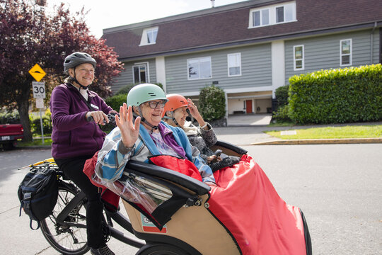 Happy Elderly Women Friends Waving, Riding In Trishaw On Street